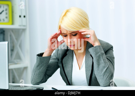 Junge schöne Geschäftsfrau denken an ihrem Arbeitsplatz im Büro Stockfoto