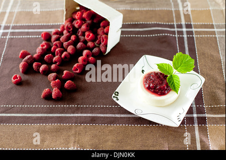 Pannacotta und Himbeeren am Tisch Stockfoto