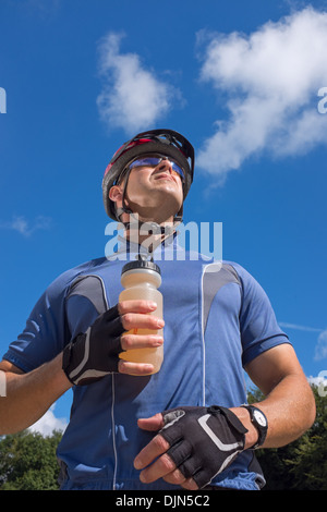 Männliche Radfahrer einen Drink in eine Flasche Wasser zu halten. Stockfoto