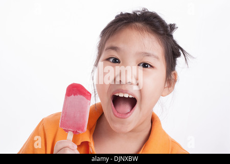 Kleine Asiatin zufrieden mit dem Essen Eis isoliert Stockfoto