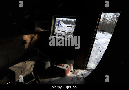 9. März 2010 - Nikolai, Alaska, USA - JOHN BAKER ist der dritte Musher aus dem Checkpoint von Nikolai wie er vorbei an eine alte Hütte auf während des Iditarod Trail Sled Dog Race 2010 in Alaska Breie. (Kredit-Bild: © Bob Hallinen/Anchorage Daily News/ZUMA Press) Stockfoto