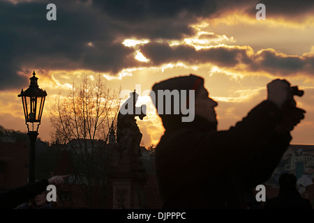 Fotografieren bei Sonnenuntergang auf der Karlsbrücke. Prag. Die Karlsbrücke ist das berühmteste Wahrzeichen Prags und verbindet die alte Stockfoto