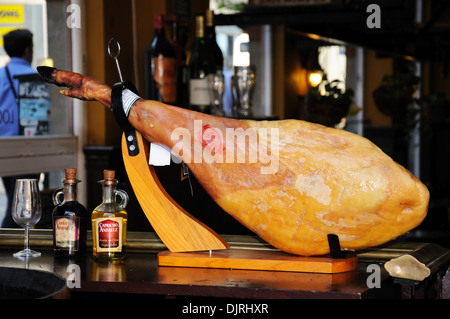 Bein der Schinken (Jamón Serrano) auf dem Tresen der eine Tapas-Bar, Malaga, Andalusien, Spanien. Stockfoto