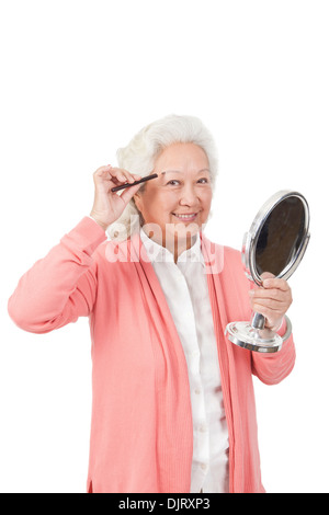 Ältere Frau Holding Spiegel Stockfoto