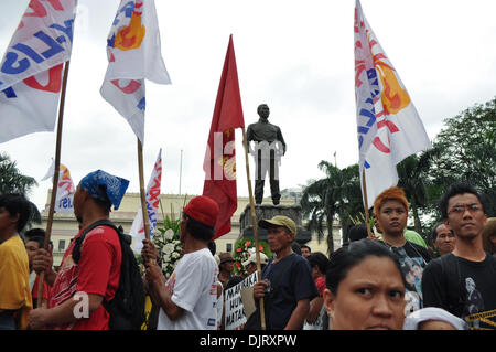 Manila, Philippinen. 30. November 2013.  Andres Bonifacio Denkmal hinter Arbeiterklasse Filipinos Raffung an der Liwasang Bonifacio als militante Gruppen Mark den 150. Geburtstag des philippinischen Patrioten, Andres Bonifacio von Samstag, 30. November 2013 Proteste und verschiedene Aktivitäten in Manila, festhalten. Unter der Leitung von nationalen Arbeitsmitte Kilusang Mayo Uno (KMU), fällt ihr Programm mit anderen Arbeits-Gruppen Proteste im Land. Bildnachweis: George Calvelo/Alamy Live-Nachrichten Stockfoto