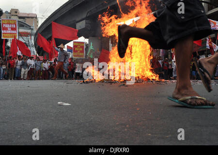 Manila, Philippinen. 30. November 2013.  Demonstranten laufen rund um die verbrannten Bildnis schreien ihre Proteste an der historischen Mendiola Brücke in San Miguel, Manila. Militante Gruppen markieren Filipino Patriot, Andres Bonifacio 150. Geburtstag, Samstag, 30. November 2013 Proteste und verschiedene Aktivitäten in Manila, festhalten. Unter Berufung auf, dass der Präsident Bonifacios Zorn verdient haben würde, wird der Protest von nationalen Arbeitsmitte Kilusang Mayo Uno (KMU), die zeitgleich mit anderen Arbeits-Gruppen Proteste im Land geführt. Bildnachweis: George Calvelo/Alamy Live-Nachrichten Stockfoto