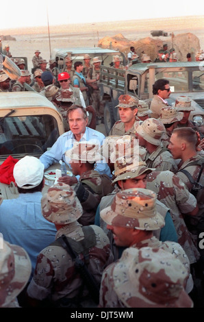 US-Präsident George Bush lehnt sich auf der Motorhaube ein Humvee, wie er mit Marines bei einem Erntedankfest-Besuch in einem einsamen Lager 22. November 1990 in Saudi Arabien spricht. Der Präsident besucht US-Truppen in Saudi-Arabien für Operation Desert Shield. Stockfoto