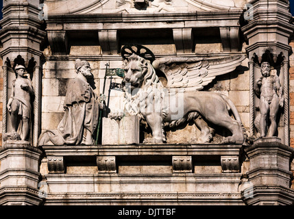 Detail-Aufnahme eines geflügelten Löwen mit ein offenes Buch und eine kniende Doge auf den Dogenpalast, Venedig, Veneto, Italien. Stockfoto