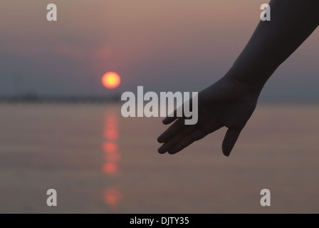 Womans Hand Silhouette gegen einen Sonnenuntergang Stockfoto