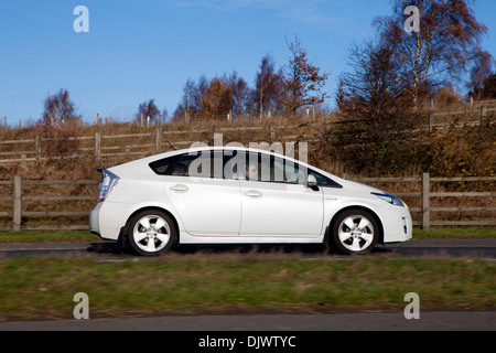 Weißen Toyota Prius Vollhybrid elektrische Mittelklasse Limousine Seitenansicht uk Straßenfahrt Stockfoto