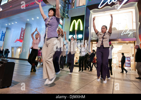 McDonald's-Mitarbeiter tanzen in der Fußgängerzone Nanjing Road - wichtigste Einkaufsstraße in Shanghai, China Stockfoto