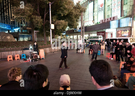 Mann singen zur Fußgängerzone Nanjing Road - wichtigste Einkaufsstraße in Shanghai, China Stockfoto