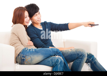 junges Paar auf Sofa vor dem Fernseher mit Fernbedienung Stockfoto