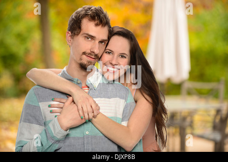 Junges Paar umarmt im Hinterhof im Herbst Stockfoto