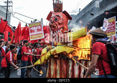 Manila, Philippinen. 30. November 2013. Labor Gruppenleiter legten Feuer auf das Bildnis zeigt den philippinischen Präsidenten als Schweinefleisch Barrel König, sitzend auf einem Fass mit dem Gesicht eines Schweins. Militante Gruppen gekennzeichnet philippinische Patriot, Andres Bonifacio 150. Geburtstag, Samstag, 30. November 2013 Proteste und verschiedene Aktivitäten in Manila, festhalten. Unter Berufung auf, dass der Präsident Bonifacios Zorn verdient haben würde, wird der Protest von nationalen Arbeitsmitte Kilusang Mayo Uno (KMU), die zeitgleich mit anderen Arbeits-Gruppen Proteste im Land geführt. Foto: George Calvelo/NurPhoto (Kredit-Bild: © George C Stockfoto