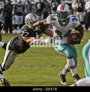 28. November 2010 - Oakland, CA, USA - Oakland Raiders Vs Miami Dolphins im Oakland-Alameda County Coliseum Sonntag, 10. Oktober 2010.  Miami Dolphins Runningback Ricky Williams #34 gestreckten Armen Oakland Raiders defensive end Matt Shaughnessy #77..Raiders locker um Delfine 33-17 (Credit-Bild: © Al Golub/ZUMAPRESS.com) Stockfoto