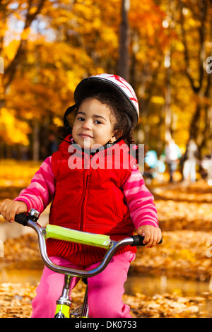 Enge Porträt von einem kleinen schwarz 3 Jahre alt schwarze Mädchen mit dem Fahrrad im Park halten streng und tragen Helm Stockfoto