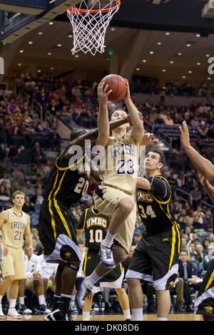 22. Dezember 2010 - Laufwerke Südschlaufe, Indiana, USA - Notre Dame Guard Ben Hansbrough (#23) in den Korb während der Verteidigung von Maryland Baltimore County vorwärts Adrian Satchell (#20) und Jake Wasco (#34) Center in Aktion während der NCAA Basketball-Spiel zwischen Maryland Baltimore County und Notre Dame.  Die Notre Dame Fighting Irish besiegte der Maryland Baltimore County Retriever 93-53 Stockfoto