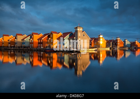 schöne bunte Gebäude auf dem Wasser im goldenen Sonnenschein, Reitdiephaven, Groningen, Niederlande Stockfoto