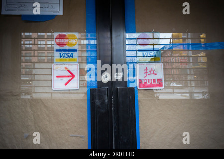 Logos für Kredit-und Debitkarten sowie ein Richtungsanzeiger in Chinesisch und Englisch Stockfoto