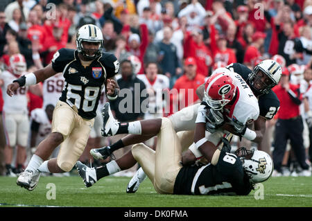 31. Dezember 2010 - Memphis, Tennessee, Vereinigte Staaten von Amerika - Georgia Bulldogs Wide Receiver Tavarres König (12) nach unten gezogen durch UCF Knights defensive back Justin Boddie (23) und UCF Knights defensive back Kemal Ishmael (18) während der NCAA Liberty Bowl-Spiel zwischen der University of Central Florida und der University of Georgia.  Zur Halbzeit sind die UCF Knights mit dem Georg gebunden. Stockfoto