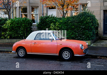 Orange farbigen Nissan Figaro Auto geparkt in Edinburgh. Stockfoto