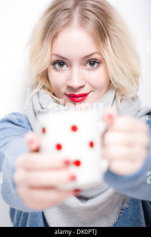 Porträt der blonden Schönheit in Winterkleidung halten Tasse Heißgetränk. Stockfoto