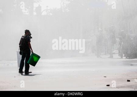 Bangkok, Thailand. 1. Dezember 2013. Ein einsamer Demonstrant Gesichter Wasserwerfer abgefeuert hinter Polizeilinien während eine Pattsituation zwischen regierungsfeindlichen Demonstranten und der Polizei, Regierungsgebäude, Bangkok, Thailand - Foto: Gavin Gough/NurPhoto (Credit-Bild: © Gavin Gough/NurPhoto/ZUMAPRESS.com) Stockfoto