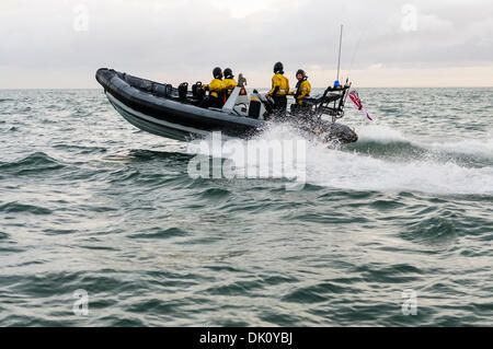 Belfast, Nordirland. 30. November 2013 - Trockenanzüge A Royal Navy VT Halmatic Pacific 22-Verfolgung, die Rippe über Wellen mit Geschwindigkeit mit vier Passagieren an Bord tragen spritzt. Bildnachweis: Stephen Barnes/Alamy Live-Nachrichten Stockfoto