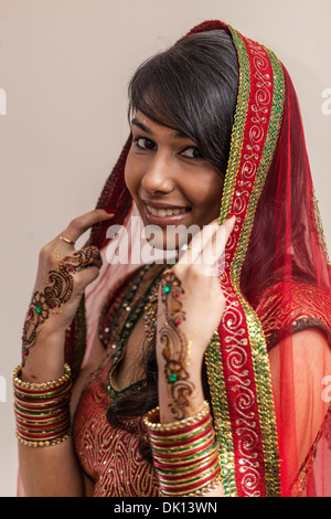 Porträt einer schönen indischen Frau gekleidet in traditioneller Kleidung und Henna-Tattoos auf ihren Händen Stockfoto