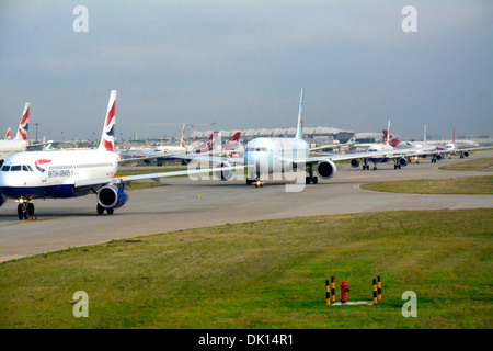 Linie von Flugzeugen, die darauf warten, von London Heathrow an einem geschäftigen Morgen ausziehen Stockfoto