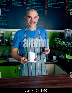 Junge Barkeeper lächelnd und Tasse Kaffee halten. Stockfoto