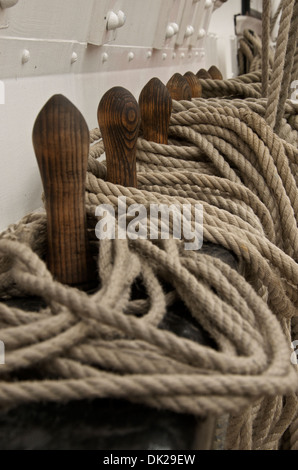 Seillängen Schiffe aufgewickelt um hölzerne Pflöcke an Bord der HMS Tölpel in der historischen Dockyard Chatham Stockfoto