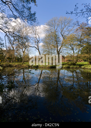 Herbstliche Bäume spiegeln sich in den Graben am Michelham Priory, Sussex Stockfoto