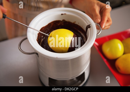 Closeup auf junge Hausfrau macht Apple in Schokoladenglasur Stockfoto