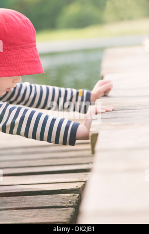 Lebensstil Augenblick Sommer Kindheit. Kleine Mädchen spielen auf Steg, Schweden Stockfoto
