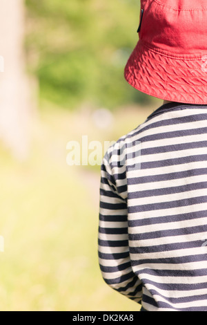 Ruhigen Sommer-Szene. Junges Mädchen mit rotem Hut stehen im Freien, Natur beobachten. Stockfoto