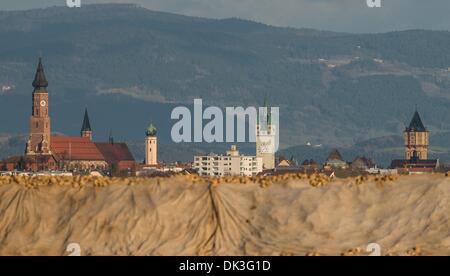 Straubing, Deutschland. 25. November 2013. Hinter einem bedeckten Berg mit Zuckerrüben, die Altstadt von Straubing mit den Türmen der gotischen Basilika St. Jakob (L-R), die Karmeliterkloster und Kirche des Heiligen Geistes, der Jesuitenkirche, dem Stadtturm und der Wasserturm in Straubing, Deutschland, 25. November 2013. Foto: Armin Weigel/Dpa/Alamy Live-Nachrichten Stockfoto