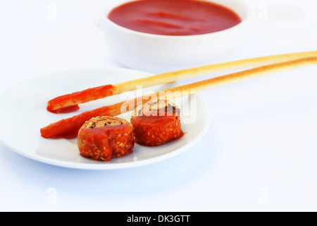 Zwieback mit Sesam, Brot-Sticks und roter Soße auf grauem Hintergrund isoliert. Stockfoto