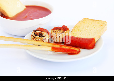 Zwieback mit Sesam, Brot-Sticks und roter Soße auf grauem Hintergrund isoliert. Stockfoto