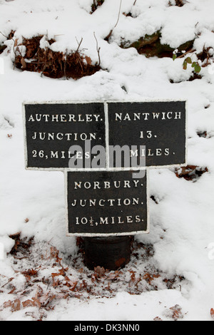 Mile post im Schnee durch den Kanal am Tyrley sperrt Shropshire Union Canal, Market Drayton, Shropshire, England Stockfoto