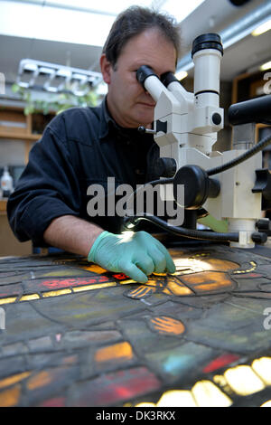 Erfurt, Deutschland. 27. November 2013. Thomas Glass, Glaser und Restaurator in der Glaswerkstatt auf den Erfurter Dom, reinigt einen eingebauten Fenster der Kathedrale in Erfurt, Deutschland, 27. November 2013. Die Wiederherstellung eines Dom-Fensters besteht aus etwa 100 einzelnen Scheiben dauert etwa zwei Jahre. Die Fenster wurden in den Jahren zwischen 1380 und 1420 gemacht. Foto: Marc Tirl/ZB/Dpa/Alamy Live News Stockfoto