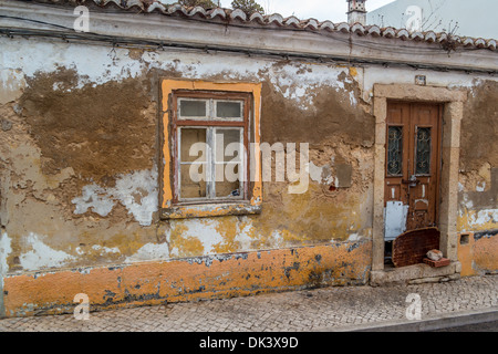 Altbau in einem Zustand des Verfalls mit Farbe und Zement blätterte von den Wänden Stockfoto