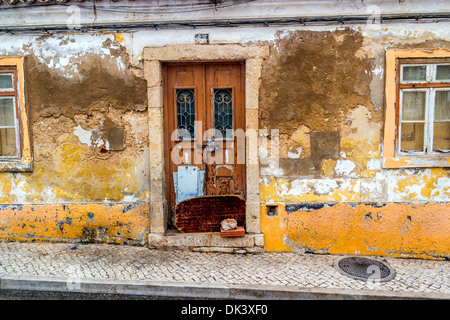 Altbau in einem Zustand des Verfalls mit Farbe und Zement blätterte von den Wänden Stockfoto