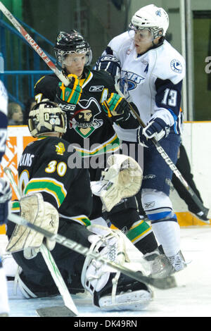 27. März 2011 - Saskatoon, Saskatchewan, Kanada - Saskatoon Blades Linksaußen Curtis Hamilton (#13) kollidiert mit dem Prince Albert Raiders-Spieler hinter Prince Albert Raiders Torwart Eric Williams (#30) in Aktion während der Saskatoon Blades Vs Prince Albert Raiders Spiel im Credit Union Centre in Saskatoon. Die Saskatoon Blades führen die Prince Albert Raiders 1-0 in den besten Stockfoto