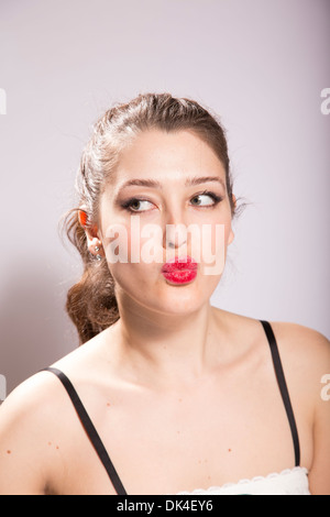 Junge Frau schmiert Lippenstift auf ihrem Gesicht Stockfoto