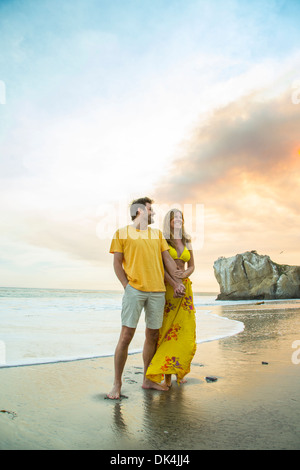 Paar am Strand entlang spazieren Stockfoto