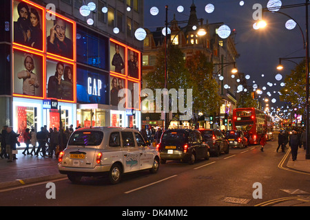 London-Taxis und Busse, die Schlange in der Oxford Street unter Weihnachtsschmuck Stockfoto