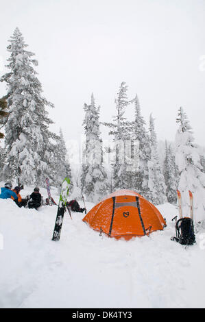 27. Februar 2011 - Missoula, Montana, USA - Sarah Ogburn (schwarze Jacke), Matt Cornette (blaue Jacke) und Pete Barrett (orange Jacke) haben einen Drink in ihrem Lager in einer Küche, die sie aus dem Schnee gegraben... Skifahrer-Camp und Ski im Hinterland von den Bitterroot Bergen von Montana. (Kredit-Bild: © Jed Conklin/ZUMAPRESS.com) Stockfoto