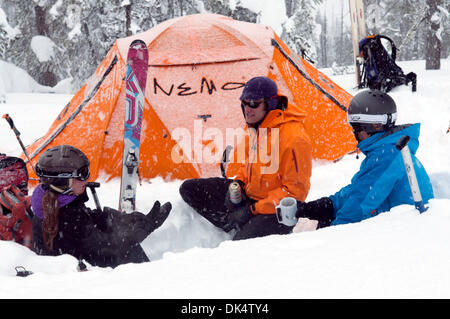 27. Februar 2011 - Missoula, Montana, USA - Sarah Ogburn (schwarze Jacke), Matt Cornette (blaue Jacke) und Pete Barrett (orange Jacke) haben einen Drink in ihrem Lager in einer Küche, die sie aus dem Schnee gegraben... Skifahrer-Camp und Ski im Hinterland von den Bitterroot Bergen von Montana. (Kredit-Bild: © Jed Conklin/ZUMAPRESS.com) Stockfoto